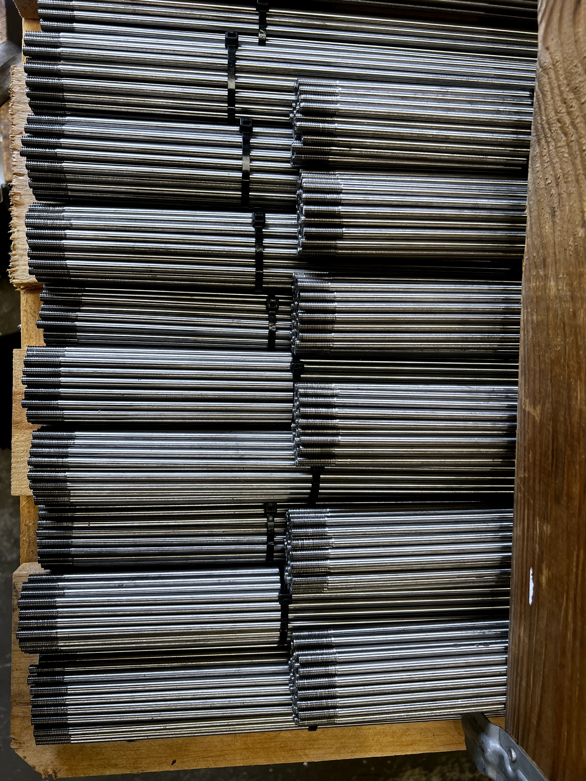 Series stangen met gesneden buitendraad, gebundeld op een pallet in de werkplaats van HB Metaalbewerking