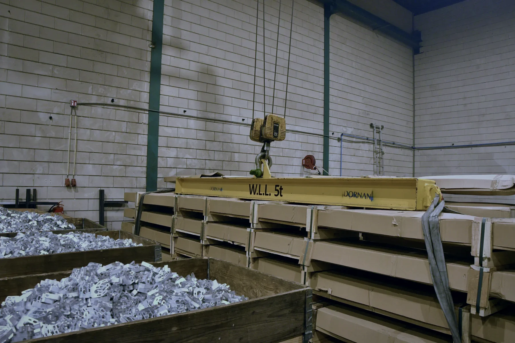 Kisten met gestanste aluminium onderdelen naast voorraad plaatmateriaal